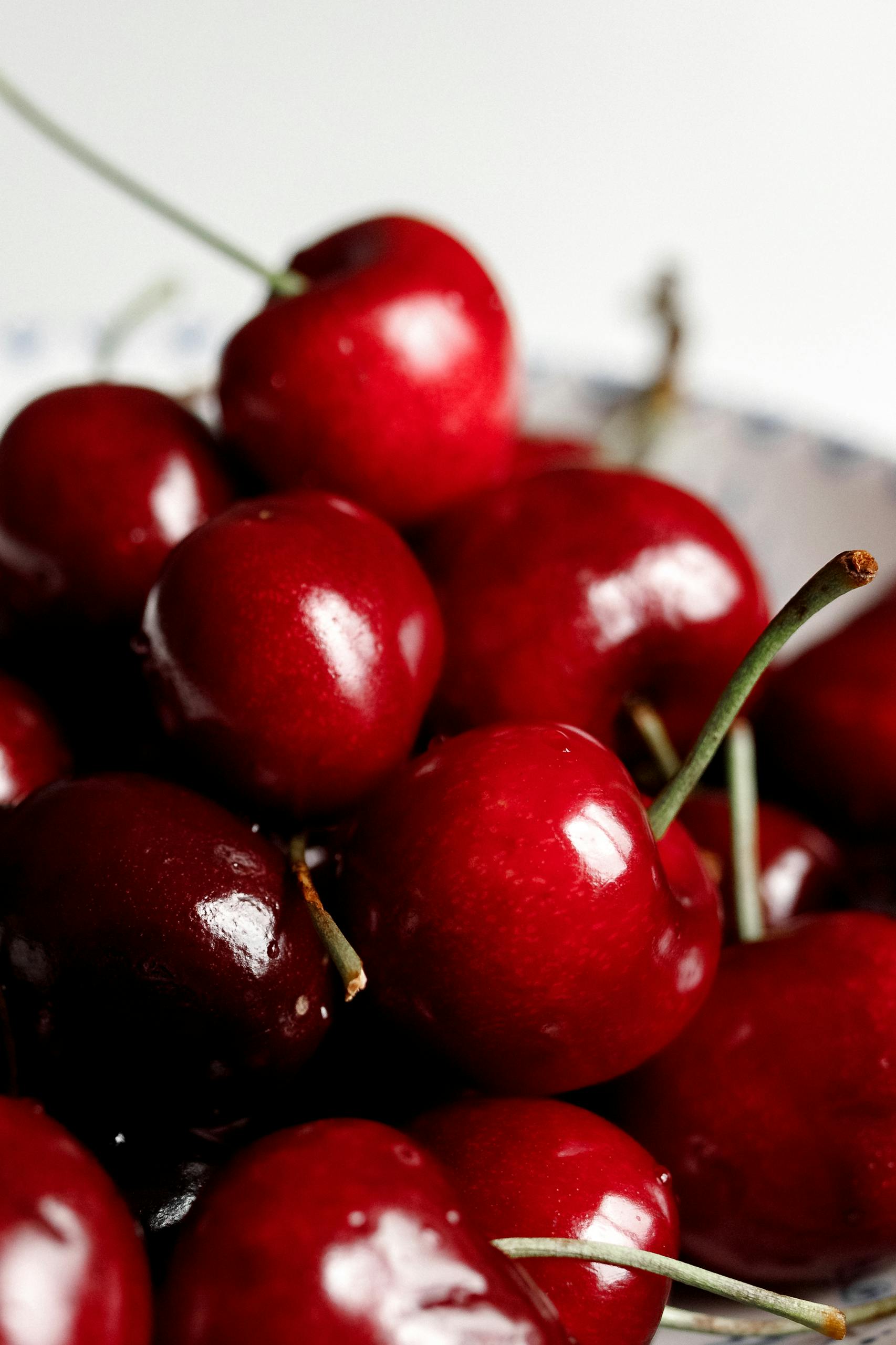 A vibrant close-up of fresh, ripe red cherries with glossy surfaces.